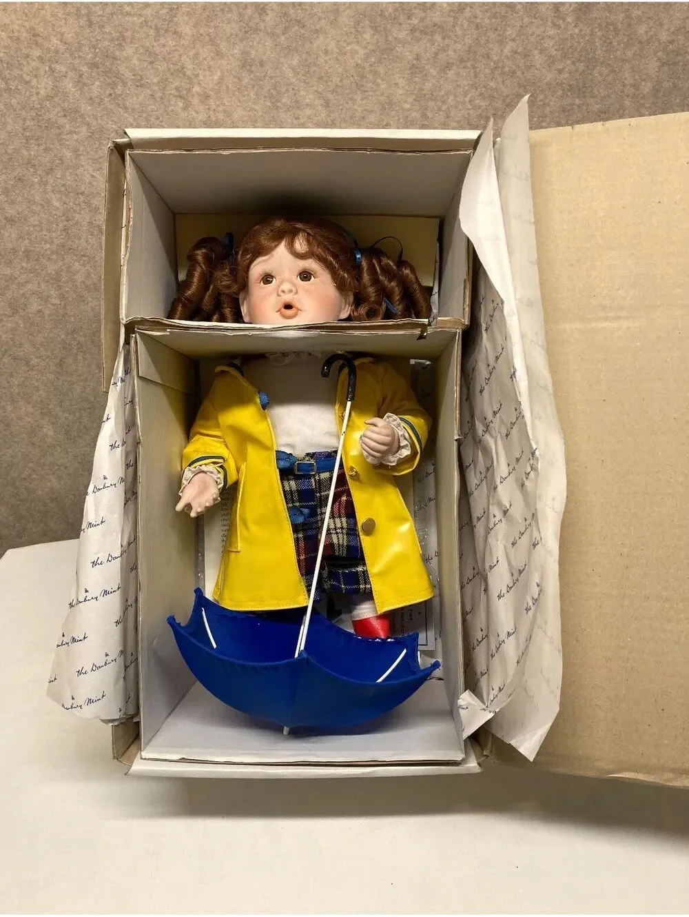 The Danbury Mint 'Kelly' Porcelain Doll with Blue Umbrella and Yellow Raincoat
